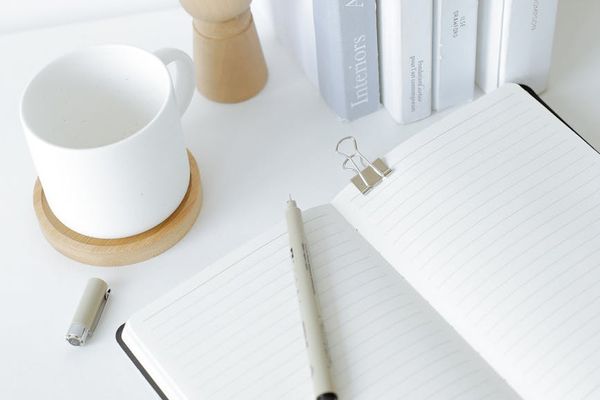 Aesthetic shot of a notebook and pen on a clean desk.